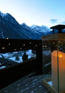 Una vela en un balcón con montañas al fondo en Superior Apartment Eva, en Heiligenblut