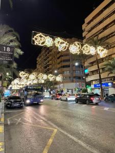 Un autobús conduciendo por una calle de la ciudad con luces de Navidad en Habitación Sol Connect, en Alicante