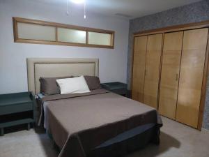 a bedroom with a bed and a large cabinet at Apartamento en Juan Dolió, Marbella in La Francia