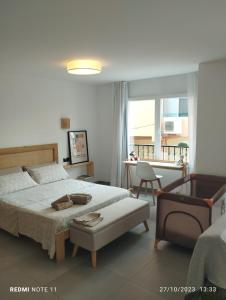 1 dormitorio con 1 cama grande y 1 silla en ALGAR LOFT, diseño y climatización, en Callosa de Ensarriá