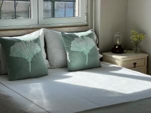 - un lit avec des draps et des oreillers blancs ainsi qu'une fenêtre dans l'établissement Quinta Janelas do Vale, à Abrantes