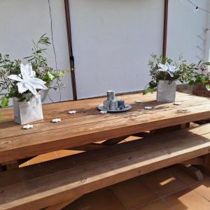 una mesa de madera con dos jarrones y flores. en Au Jardin d'Armand, en Sant Pere de Ribes