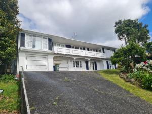 a white house with a driveway in front of it at Hillcrest Villa in Auckland