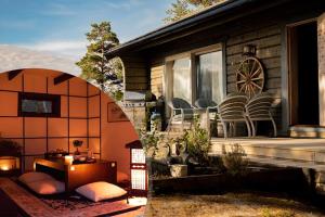 ein Haus mit einer Terrasse mit einem Tisch und Stühlen in der Unterkunft Cozy Cabin in Stockholms Archipelago in Ingmarsö