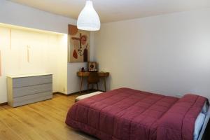 sypialnia z purpurowym łóżkiem i stołem w obiekcie Assisi Suite Relax, Bilocale nel centro storico w Asyżu