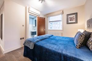a bedroom with a blue bed and a window at CAMDEN Lux Apartment-Hosted by Sweetstay in London