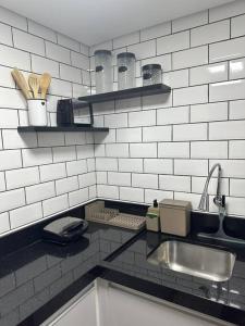 uma cozinha com um lavatório e uma bancada em Studio Moderno e Aconchegante em Perdizes em São Paulo