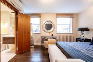 a bedroom with a bed and a sink and a mirror at CAMDEN Lux Suite-Hosted by Sweetstay in London