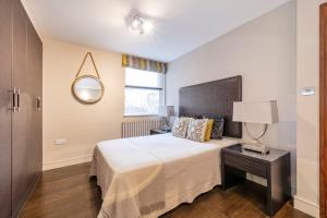 a bedroom with a large bed and a mirror at CAMDEN Lux Suite-Hosted by Sweetstay in London