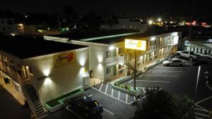 a parking lot in front of a building at night at Super 8 by Wyndham Oceanside Downtown in Oceanside
