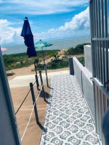 a blue umbrella on a balcony with the beach at BL Maria Bonita Pousada in Maragogi