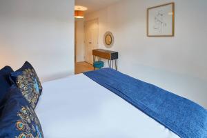 Un dormitorio con una cama con una manta azul. en Modern Comfort 2BR Apartment - FREE Parking - FAST Internet en Oadby
