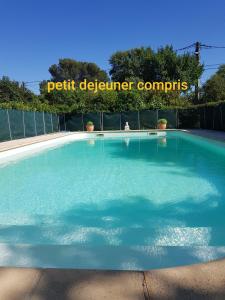 uma grande piscina de água com um sinal que lê pequenos computadores dellear em Cap au Sud Sweet home em Nîmes