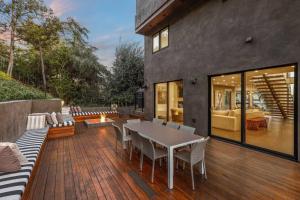 une terrasse en bois avec une table et des chaises. dans l'établissement Luxurious Modern Mansion Hollywood Hills, à Los Angeles