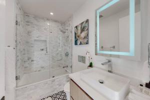 a white bathroom with a sink and a shower at Luxurious Modern Mansion Hollywood Hills in Los Angeles