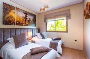 sypialnia z 2 łóżkami i oknem w obiekcie Appartement de luxe avec jardin privé w Marakeszu