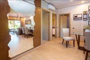 een woonkamer met een tafel en een eetkamer bij Appartement de luxe avec jardin privé in Marrakesh