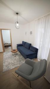 a living room with a blue couch and a mirror at Madulo apartman in Jahorina
