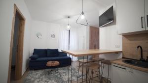 a small kitchen with a blue couch and a table at Madulo apartman in Jahorina