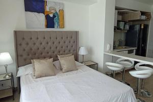 1 dormitorio con 1 cama blanca grande y 2 sillas blancas en New Beach loft in Cartagena close to the airport, en Cartagena de Indias