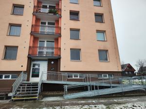 an apartment building with stairs in front of it at Apartmán Rokytnička in Rokytnice v Orlických Horách