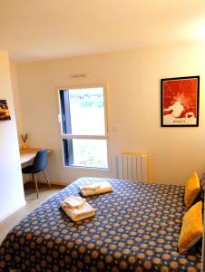 a bedroom with a bed with two towels on it at Chez Clo & Tonio in Saint-Hélen
