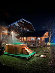 a building with a hot tub in the yard at night at Gazdovský dvor B&B s Mini Wellness in Bešeňová