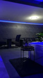 Cette chambre est dotée de lumières bleues, d'une table et de chaises. dans l'établissement Relaxation House: Jacuzzi, Sauna, à Übach-Palenberg
