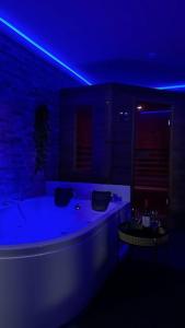 - un éclairage bleu dans la salle de bains pourvue d'une baignoire dans l'établissement Relaxation House: Jacuzzi, Sauna, à Übach-Palenberg