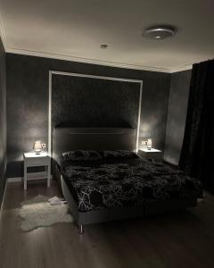 - une chambre avec un lit et 2 tables de nuit dans l'établissement Relaxation House: Jacuzzi, Sauna, à Übach-Palenberg