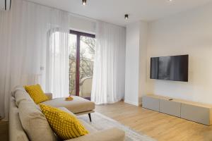 a living room with a couch and a tv at P&O Apartments Sułkowicka - Mokotów in Warsaw