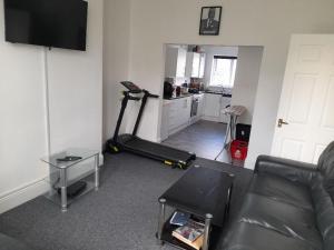 a living room with a treadmill and a kitchen at ACCANE in Monkwearmouth