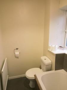 a bathroom with a white toilet and a sink at Kempston Cosy Lodge in Bedford