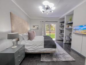 una camera da letto con un letto e un tavolo con una lampada di Amoris Guesthouse - Sandton a Johannesburg