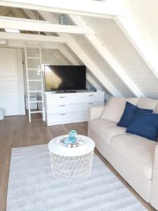 sala de estar con sofá blanco y TV en Ein bisschen Luxusfeeling direkt am Neusiedler See, en Rust
