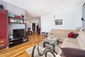 a living room with a couch and a tv at Apartment Ela with private jacuzzi in Podgora