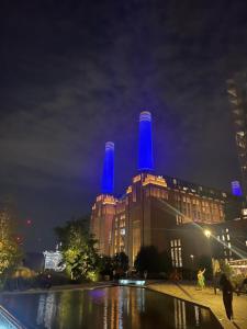 un edificio con luces azules encima por la noche en Bright new flat in Battersea, en Londres