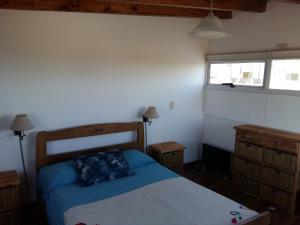 Un dormitorio con una cama azul y una ventana en Estancia de Campo en Estancia Vieja