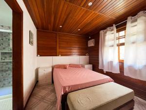 a small bedroom with a bed and a window at Angra Pier600 Casa beira mar in Angra dos Reis