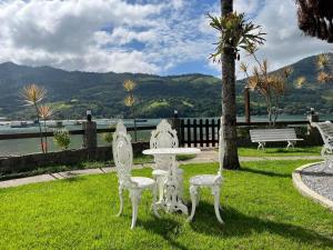 a table and chairs in a park with a view of the water at Angra Pier600 Casa beira mar in Angra dos Reis