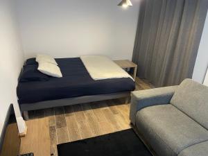 a small bedroom with a bed and a couch at Studio bien situé & tout équipé dans une maison in Scionzier