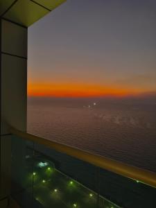 a room with a view of the ocean at sunset at Dream Beach View in Ajman 