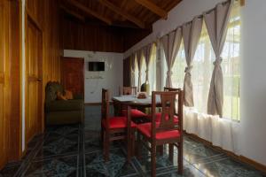 een eetkamer met een tafel en stoelen en een raam bij HeCo House in Monteverde Costa Rica