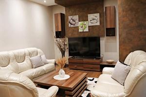 a living room with two white couches and a tv at Capital apartments Sarajevo in Sarajevo