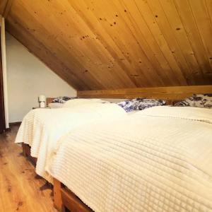 twee bedden in een kamer met een houten plafond bij Domek na Modyni in Łącko