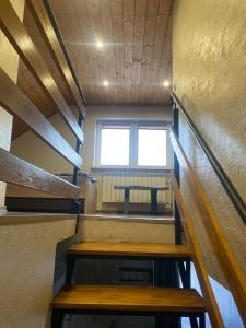 eine Treppe in einem Zimmer mit einem Tisch und einem Fenster in der Unterkunft Stawiska nad Tanwią - Roztoczański Hostel in Jędrzejówka