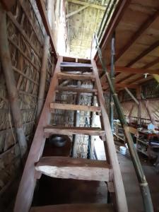 una escalera de madera en una habitación con techo de madera en El Bamboo Cabins en Balgue