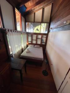 a small room with two beds and a window at Perla Negra Beachfront in Puerto Viejo