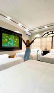 a woman standing in a hotel room with her arms in the air at Hotel Villa Antigua in San Salvador