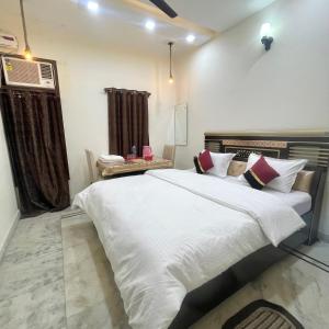 ein Schlafzimmer mit einem großen weißen Bett in einem Zimmer in der Unterkunft Homestay Comforts 500m from Amritsar Airport in Amritsar